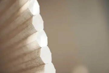 Beiges Wabenplissee mit isolierender Struktur am Fenster